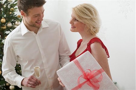 simsearch:659-03526649,k - Woman holding large Christmas parcel, man holding glass of wine Stock Photo - Premium Royalty-Free, Code: 659-03526671