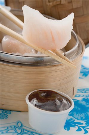 Dim sum in bamboo steamer and on chopsticks, dip (Asia) Stock Photo - Premium Royalty-Free, Code: 659-03527641