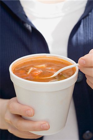 Woman eating minestrone out of a beaker Stock Photo - Premium Royalty-Free, Code: 659-03528050