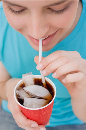 Young woman drinking cola through a straw Stock Photo - Premium Royalty-Free, Code: 659-03528384