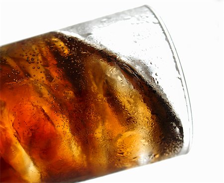Cola with ice cubes in glass (tilted) Stock Photo - Premium Royalty-Free, Code: 659-03528466