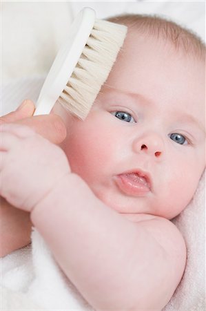 Hand brushing a baby's hair with a soft brush Stock Photo - Premium Royalty-Free, Code: 659-03528662