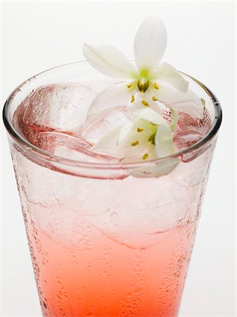 simsearch:659-01850296,k - Tequila Sunrise with ice cubes and flowers Stock Photo - Premium Royalty-Free, Code: 659-03528922