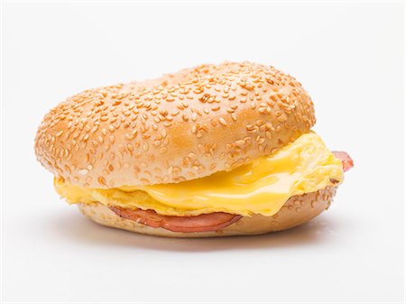 Sesame bagel filled with scrambled egg, cheese and ham Stock Photo - Premium Royalty-Free, Code: 659-03529725