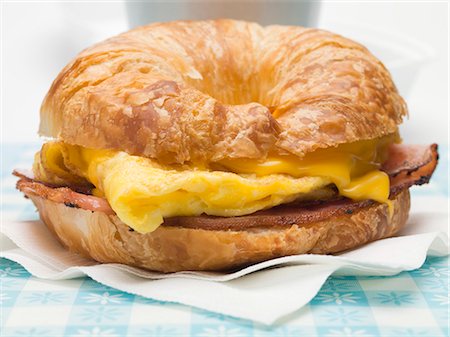 Croissant with scrambled egg, cheese & bacon (close-up) Stock Photo - Premium Royalty-Free, Code: 659-03529722