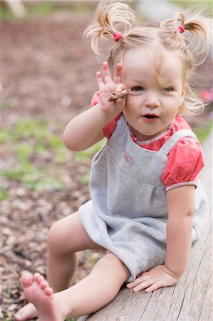 Little girl eating nut chocolate in park Stock Photo - Premium Royalty-Free, Code: 659-03529835