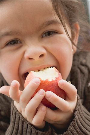 Girl biting into an organic apple Stock Photo - Premium Royalty-Free, Code: 659-03521668