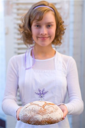 Girl holding bread she has baked herself Stock Photo - Premium Royalty-Free, Code: 659-03522477