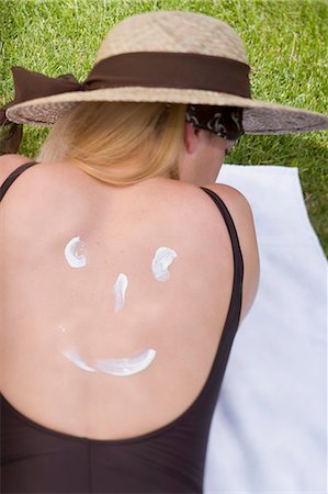 Woman in sun hat with suncream on her back Stock Photo - Premium Royalty-Free, Code: 659-03522546
