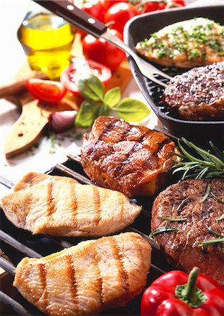 Various meats on barbecue and in grill frying pan Stock Photo - Premium Royalty-Free, Code: 659-03534357