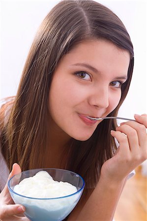 Girl eating yoghurt Foto de stock - Sin royalties Premium, Código: 659-03534792