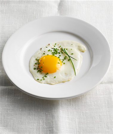 egg dish - Plate with fried egg and chives on a linen tablecloth Stock Photo - Premium Royalty-Free, Code: 659-03535326