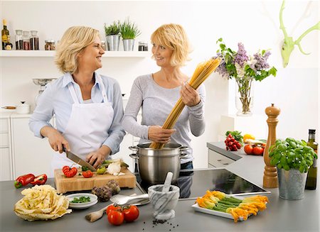 friends cooking inside - Women having a laugh while cooking spaghetti Stock Photo - Premium Royalty-Free, Code: 659-03535424