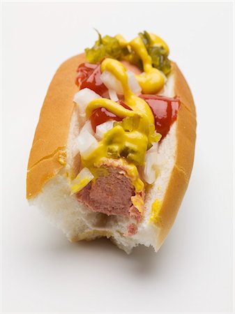 Hot dog with mustard, relish, ketchup & onions (partly eaten) Stock Photo - Premium Royalty-Free, Code: 659-03535655