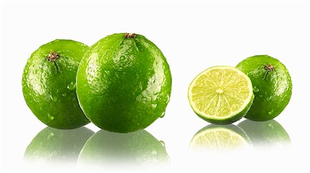 Limes, whole and halved, with drops of water and reflections Stock Photo - Premium Royalty-Free, Code: 659-03535883