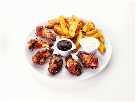 Barbecue chicken wings with potato wedges and dips Stock Photo - Premium Royalty-Free, Code: 659-03536121