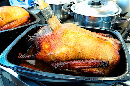 simsearch:659-01857024,k - Brushing stuffed roast goose with roasting juices Stock Photo - Premium Royalty-Free, Code: 659-03537731