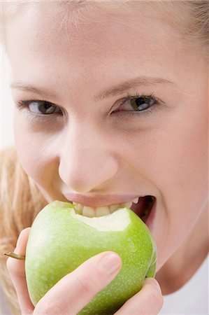 Woman eating green apple Stock Photo - Premium Royalty-Free, Code: 659-03531981