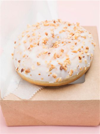 frosted - Iced doughnut with chopped nuts Stock Photo - Premium Royalty-Free, Code: 659-03532239