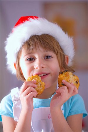 santa claus hat - Little girl in Santa hat eating raisin biscuits Stock Photo - Premium Royalty-Free, Code: 659-03533126