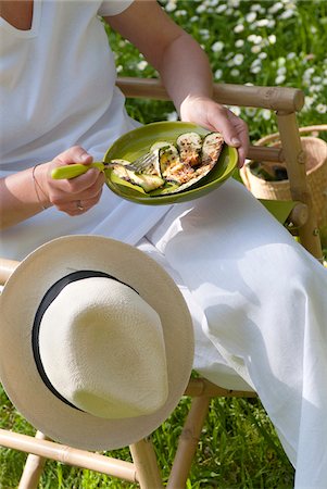 Person eating grilled zucchinis outdoors Stock Photo - Premium Royalty-Free, Code: 652-05806958