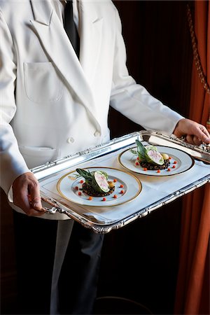serving gourmet food - Waiter carrying a tray with two plates of stuffed cabbage with lentils Stock Photo - Premium Royalty-Free, Code: 652-05807600