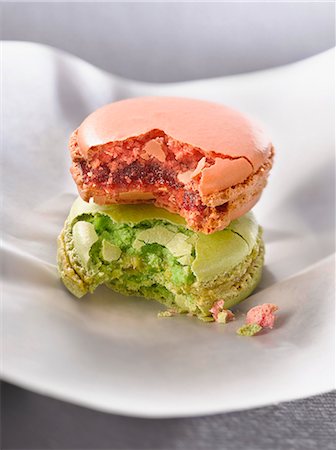 Half eaten rose-flavored and pistachio macaroons Stock Photo - Premium Royalty-Free, Code: 652-06818742