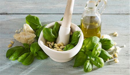 Preparing pesto with basil,pine nuts,parmesan and olive oil in a mortar Stock Photo - Premium Royalty-Free, Code: 652-06819289