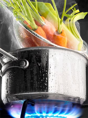 Steam cooking carrots in a saucepan on a gas cooker Stock Photo - Premium Royalty-Free, Code: 652-02222866