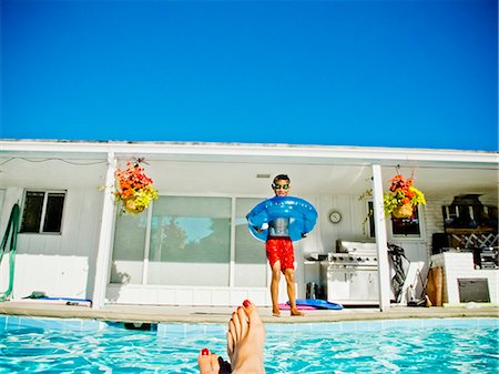 family yard - Boy in floaty standing next to pool Stock Photo - Premium Royalty-Free, Code: 673-06025523