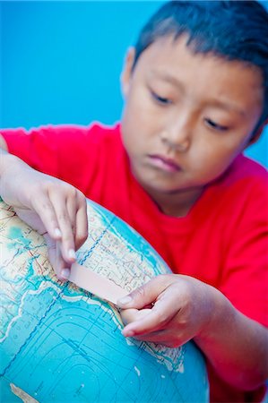 Boy placing bandaid on globe Stock Photo - Premium Royalty-Free, Code: 673-06110888