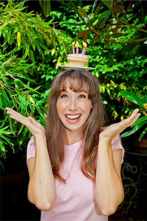 Woman with birthday cupcake on head Stock Photo - Premium Royalty-Free, Code: 673-06964519