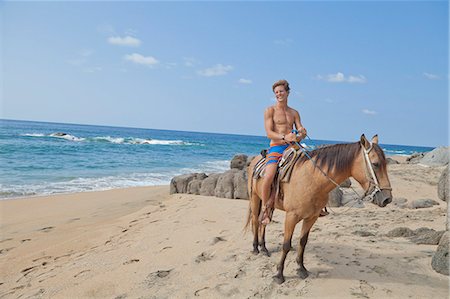 simsearch:859-07284165,k - Young man riding horse on beach Stock Photo - Premium Royalty-Free, Code: 673-06964668