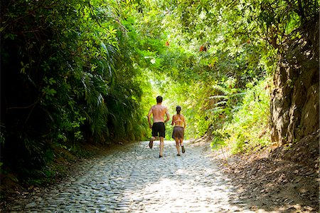 Couple walking down tree arched path Stock Photo - Premium Royalty-Free, Code: 673-06964742