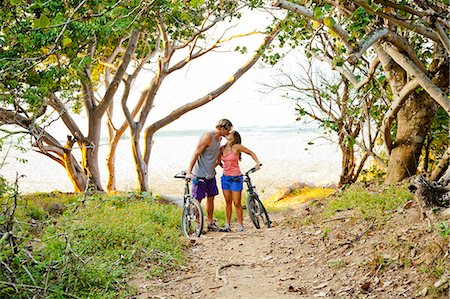 Couple riding bicycles on path to beach Stock Photo - Premium Royalty-Free, Code: 673-06964799
