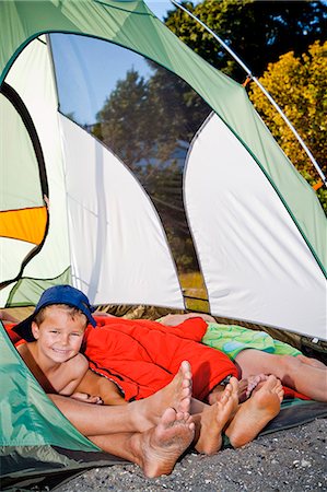 Young boy's face and pairs of feet poking out of tent Stock Photo - Premium Royalty-Free, Code: 673-06964814