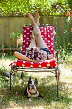 people in garden - Woman with rollers in her hair lounges in her garden with a Boston Terrier Stock Photo - Premium Royalty-Free, Code: 673-08139136