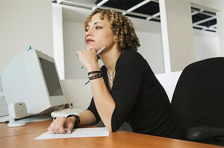 A young woman working at her desk. Stock Photo - Premium Royalty-Free, Code: 673-02137589