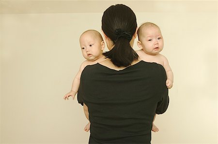 A mother holding her twin babies. Stock Photo - Premium Royalty-Free, Code: 673-02137607