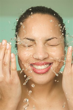 A smiling woman washing her face. Stock Photo - Premium Royalty-Free, Code: 673-02137661