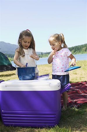 summer camping fire - Young sisters preparing food on a cooler at a campsite. Stock Photo - Premium Royalty-Free, Code: 673-02137830