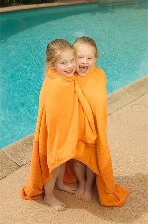 Young, twin Caucasian girls share a towel poolside. Foto de stock - Sin royalties Premium, Código: 673-02137899