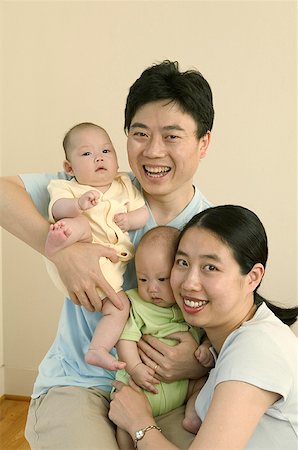 Un couple embrassant leurs bébés jumeaux. Photographie de stock - Premium Libres de Droits, Code: 673-02138034