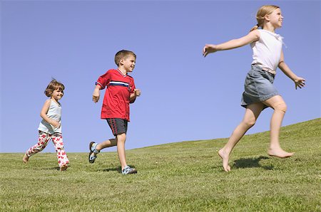 Trois enfants qui courent le long d'une colline. Photographie de stock - Premium Libres de Droits, Code: 673-02138128