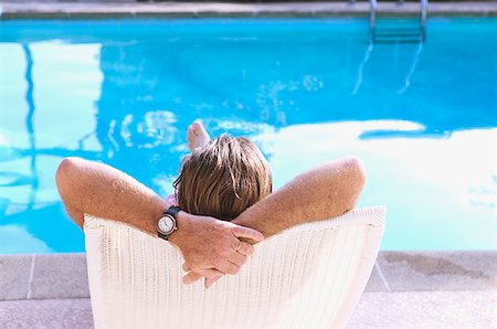 simsearch:673-02138072,k - Rear view of a man relaxing in a poolside lounge chair. Stock Photo - Premium Royalty-Free, Code: 673-02138233