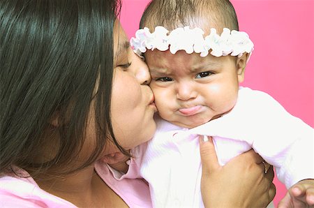 Young mother kissing her baby daughter on the cheek. Foto de stock - Sin royalties Premium, Código: 673-02138350