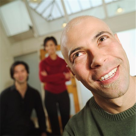 Man with two colleagues in the background. Stock Photo - Premium Royalty-Free, Code: 673-02138368