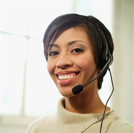 Portrait d'une femme souriante, multi-ethnic, 30 ans, portant un casque de téléphone. Photographie de stock - Premium Libres de Droits, Code: 673-02138378