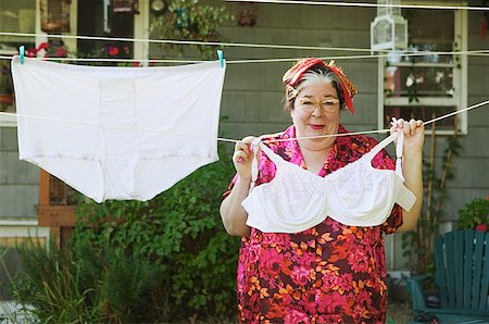 Woman hanging oversized underwear on a clothesline. Stock Photo - Premium Royalty-Free, Code: 673-02138553