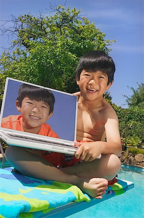 simsearch:673-02139140,k - A young boy poolside with a laptop computer Stock Photo - Premium Royalty-Free, Code: 673-02138706